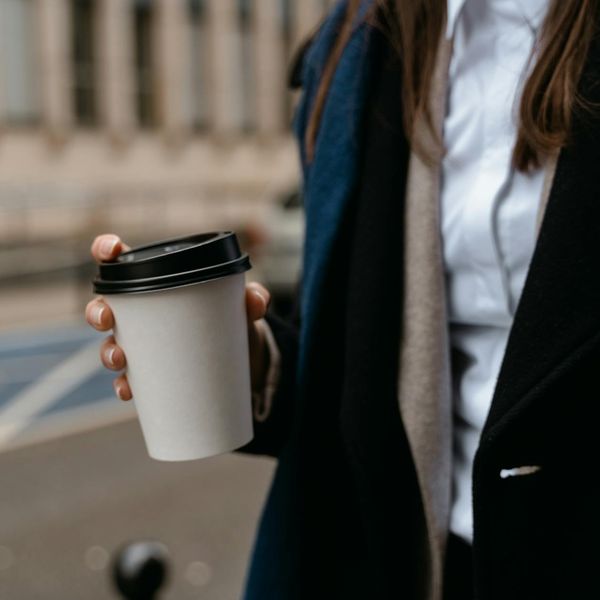 Smiling person in comfortable clothes stretching outdoors at sunrise.
